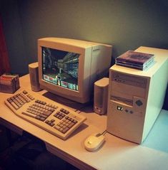 an old desktop computer sitting on top of a desk next to a keyboard and mouse