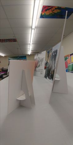 an office cubicle with two large white letters on the wall and pictures hanging from the ceiling