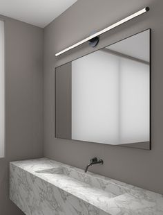 a bathroom with a marble counter top and two sinks under a large mirror above it