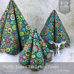 three colorful cones are sitting on a white furnishing with the words puffy pines tailorton trees written below them