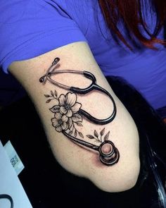 a woman with a tattoo on her arm has a stethoscope and flowers