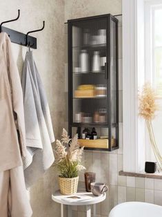 a bathroom with a towel rack next to a bath tub and a chair in it