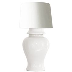 a white table lamp with a white shade on it