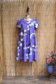 Hilo Hattie Vintage Floral Hawaiian Cotton Dress. Bright and vibrant! This vintage flowing Hawaiian Mumu style dress by The Hawaiian Original is bursting with white plumeria flowers, green and black fern pattern on a dusty lavender. Perfect for a tiki party or any summer day at the beach. It has a side pocket. Adorable scalloped sleeves.  Made in the Hawaii B: 38" W:40" H:58" L: 40 White Plumeria Flowers, Mrs Roper, White Plumeria, Scalloped Sleeves, Fern Pattern, Dusty Lavender, Plumeria Flowers, Tiki Party, Flowers Green