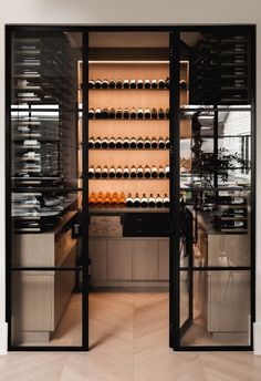 an open wine cellar with many bottles on the wall and shelves full of glasses in it