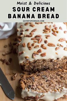 a loaf of banana bread with cream cheese frosting and pecans in the background