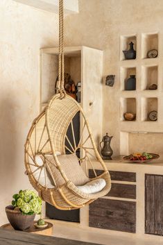 a rattan chair hanging from a rope in a living room