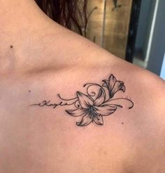 a woman's back with a flower tattoo on her left shoulder and the word love written in cursive writing