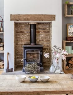 a living room filled with furniture and a fire place in front of a brick wall