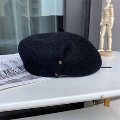 a black hat sitting on top of a white table