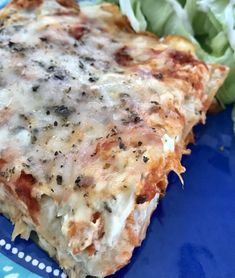 a slice of pizza sitting on top of a blue plate next to lettuce