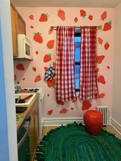 a kitchen area with a rug, stove and window covered in strawberry wall decals