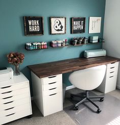 a desk with drawers and some pictures on the wall above it, along with other office supplies