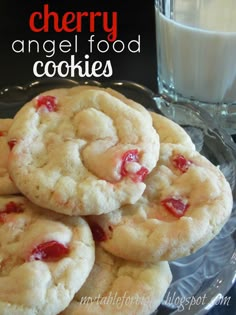 cherry angel food cookies stacked on top of each other next to a glass of milk