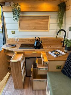 the interior of a tiny home with wood flooring and drawers on the kitchen counter