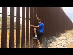 a man climbing up the side of a metal fence