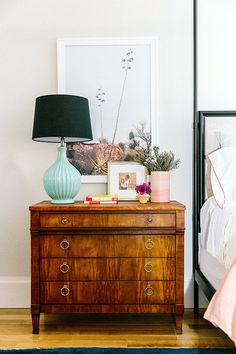 a bedroom with a dresser, bed and pictures on the wall next to each other