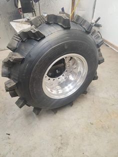 a large truck tire sitting on top of a cement floor