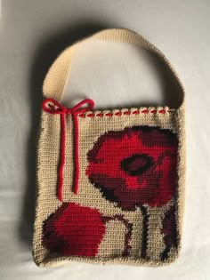 a small purse with a red flower on it