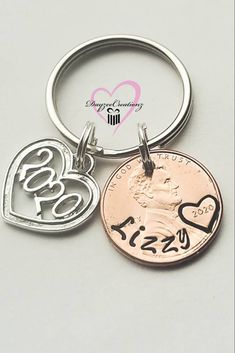 two heart shaped key chains are attached to a coin