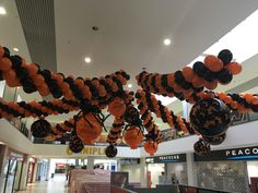 an orange and black balloon decoration hangs from the ceiling