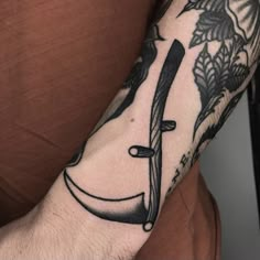 a man with a tattoo on his arm holding a knife