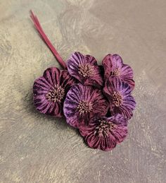 three purple flowers sitting on top of a table