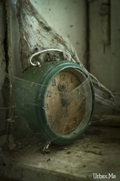 an old green clock sitting on the ground