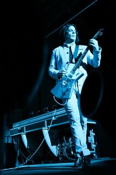 a man playing an electric guitar on stage