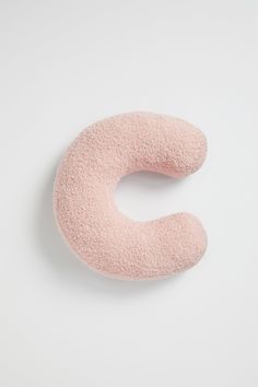 a pink pillow shaped like the letter c