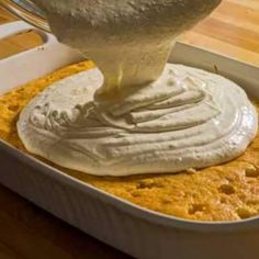 a person mixing cream into a cake in a pan