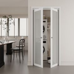 an open door in the middle of a kitchen with black and white decor on the walls