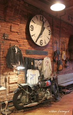 a motorcycle parked in front of a brick wall with a clock on it's face