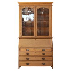 an old fashioned wooden china cabinet with glass doors on the front and drawers below it