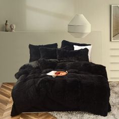 a bed with black comforter and pillows in a room