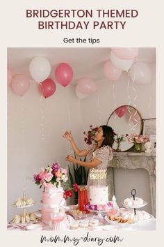 a woman standing in front of a table with pink and white balloons, cake and cupcakes