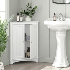 a white sink sitting next to a mirror in a bathroom