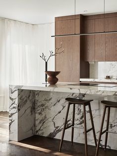 a marble kitchen island with two stools next to it