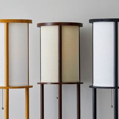 three lamps are lined up on the wall, one is white and one is brown