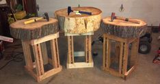 three wooden stools made out of tree trunks with tools on them in a garage