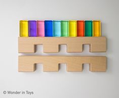 a wooden toy with rainbows in it on a white background and the words wonder in toys written below