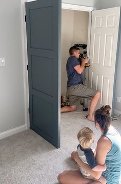 three people sitting on the floor in front of an open door taking pictures with their cameras