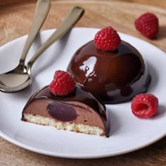 two pieces of chocolate cake on a plate with raspberries