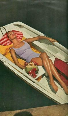 a woman laying on top of a white boat