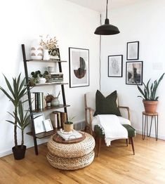 a living room filled with lots of furniture and plants on top of wooden flooring