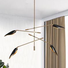 a modern chandelier hanging from a ceiling in a living room with curtains on the windowsill