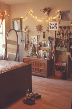 a bedroom with a bed, mirror and other items on the wall above it in front of a window