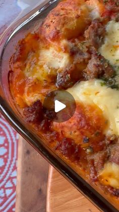 a casserole dish with meat and cheese in it on a wooden table top