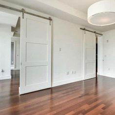 an empty room with white walls and wooden floors