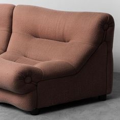 a brown couch sitting on top of a cement floor